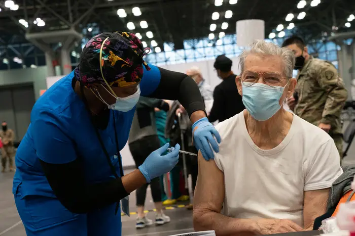 An unidentified man receives a COVID-19 immunization on opening day of the large-scale vaccination site at the The Javits Center